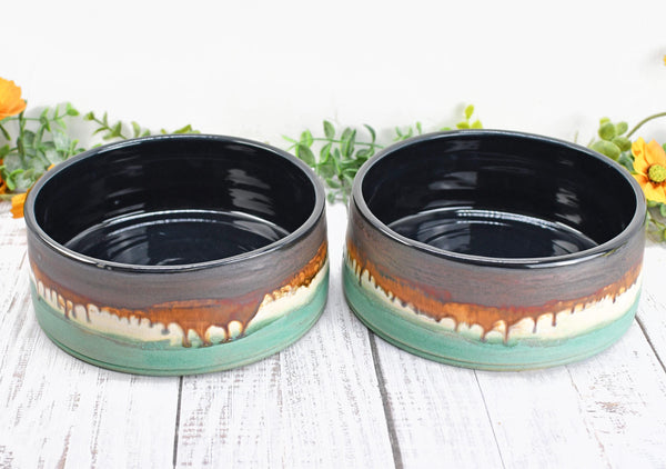 Two Ceramic Dog Food or Water Bowls in Bronze, Verdigris Green and Black glazes. Side by side Handmade Stoneware Pottery, Wheel Thrown, Medium to Large Size Pet Dishes made by artist Camille Woodward.